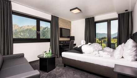Cozy hotel room with tasteful decor and a view of the mountains.