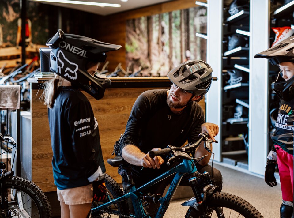 A seller explains the mountain bike to the kids.