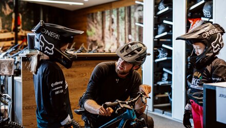 Ein Verkäufer erklärt den Kindern ihr Mountainbike.