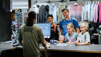 A family is being assisted at the counter of a sports store.