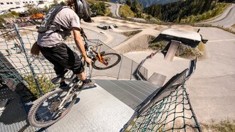 Ein Mountainbiker fährt eine steile Rampe hinunter.