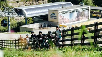 Group of mountain bikers in front of the Waldbahn with their bikes.