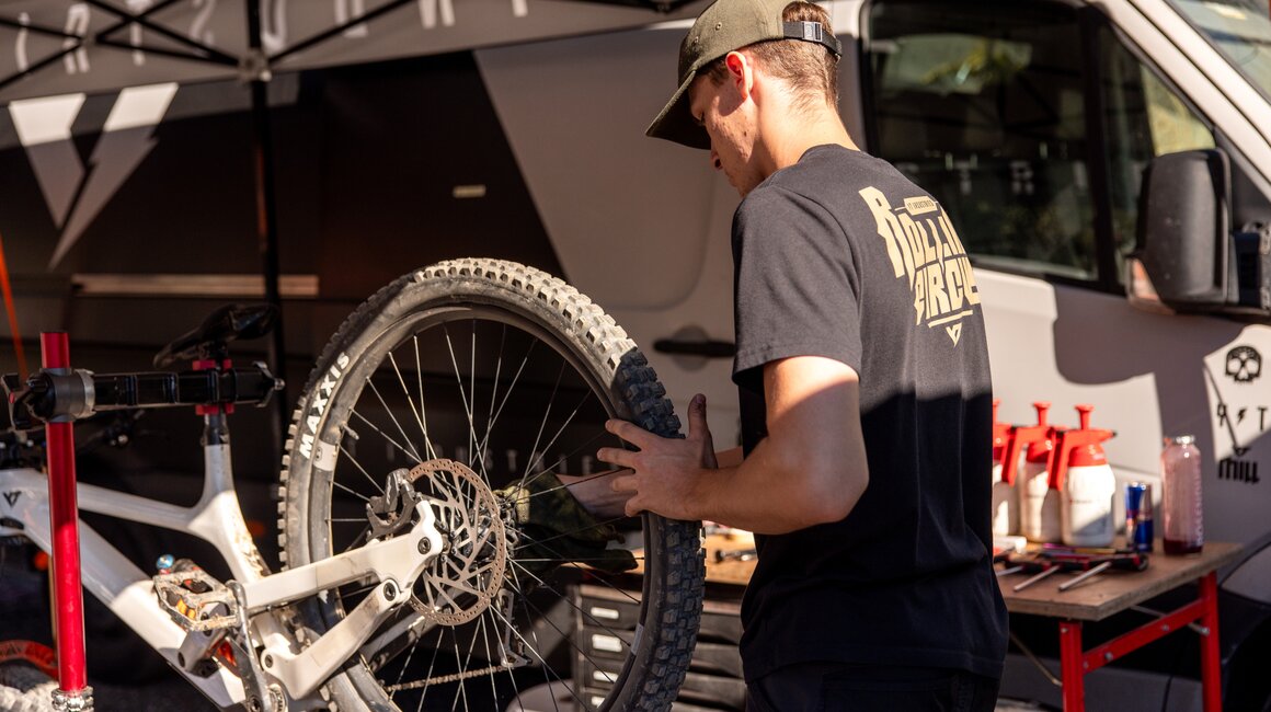 A worker is repairing a mountain bike outdoors.