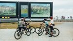 Vier Radfahrer betrachten Karten an einer Bergstation.