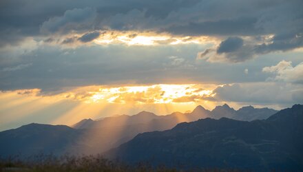 A stunning sunset with rays shining over the mountains.